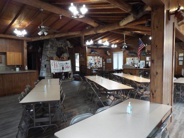 perry gun club log cabin interior with hanging lights and wooden beams