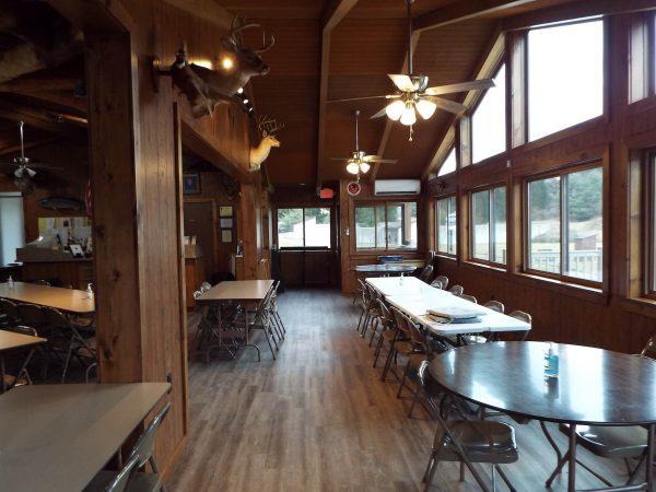 perry gun club interior tables facing large windows in a log cabin inspired interior